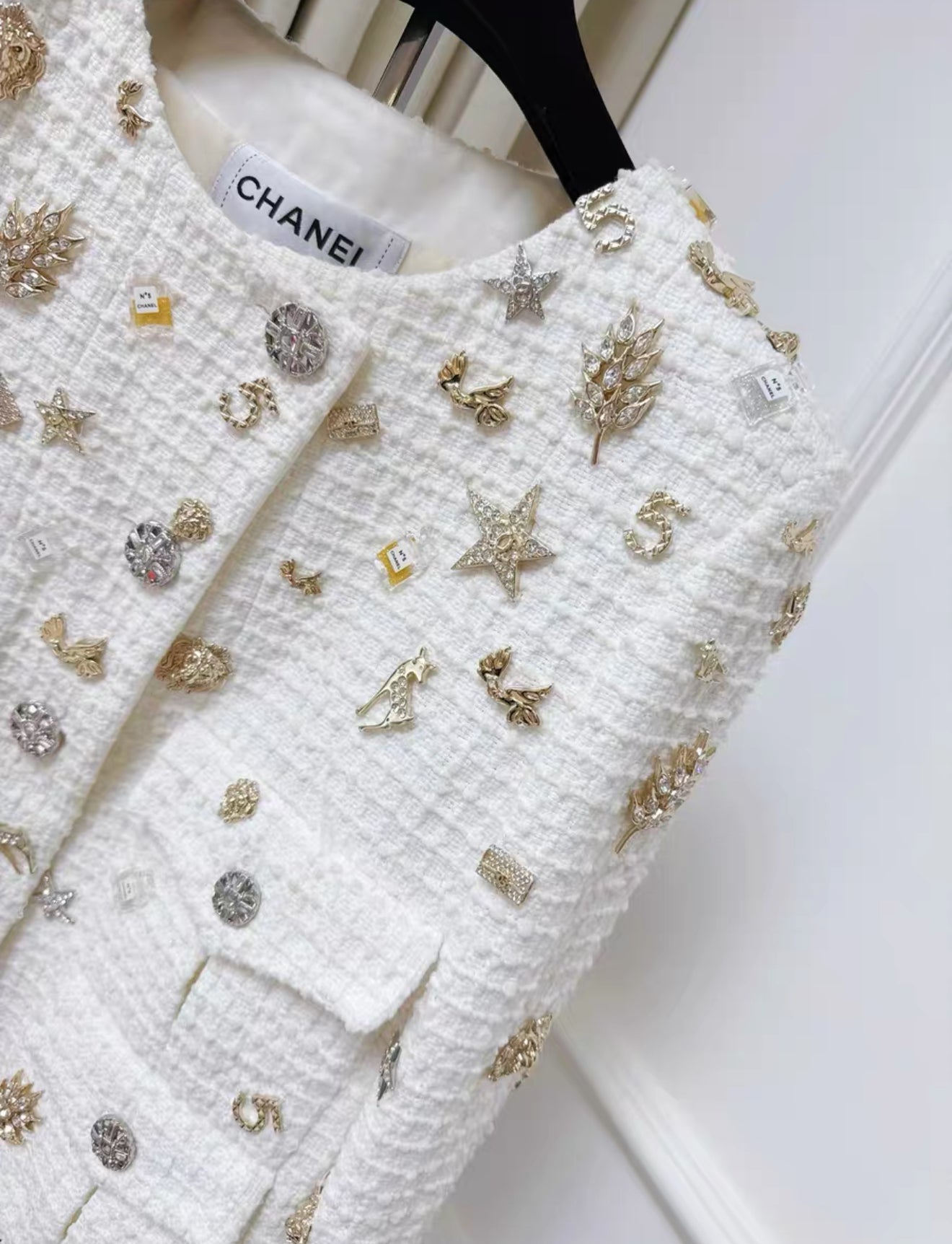 Chanel 22C White tweed jacket decorated with charms