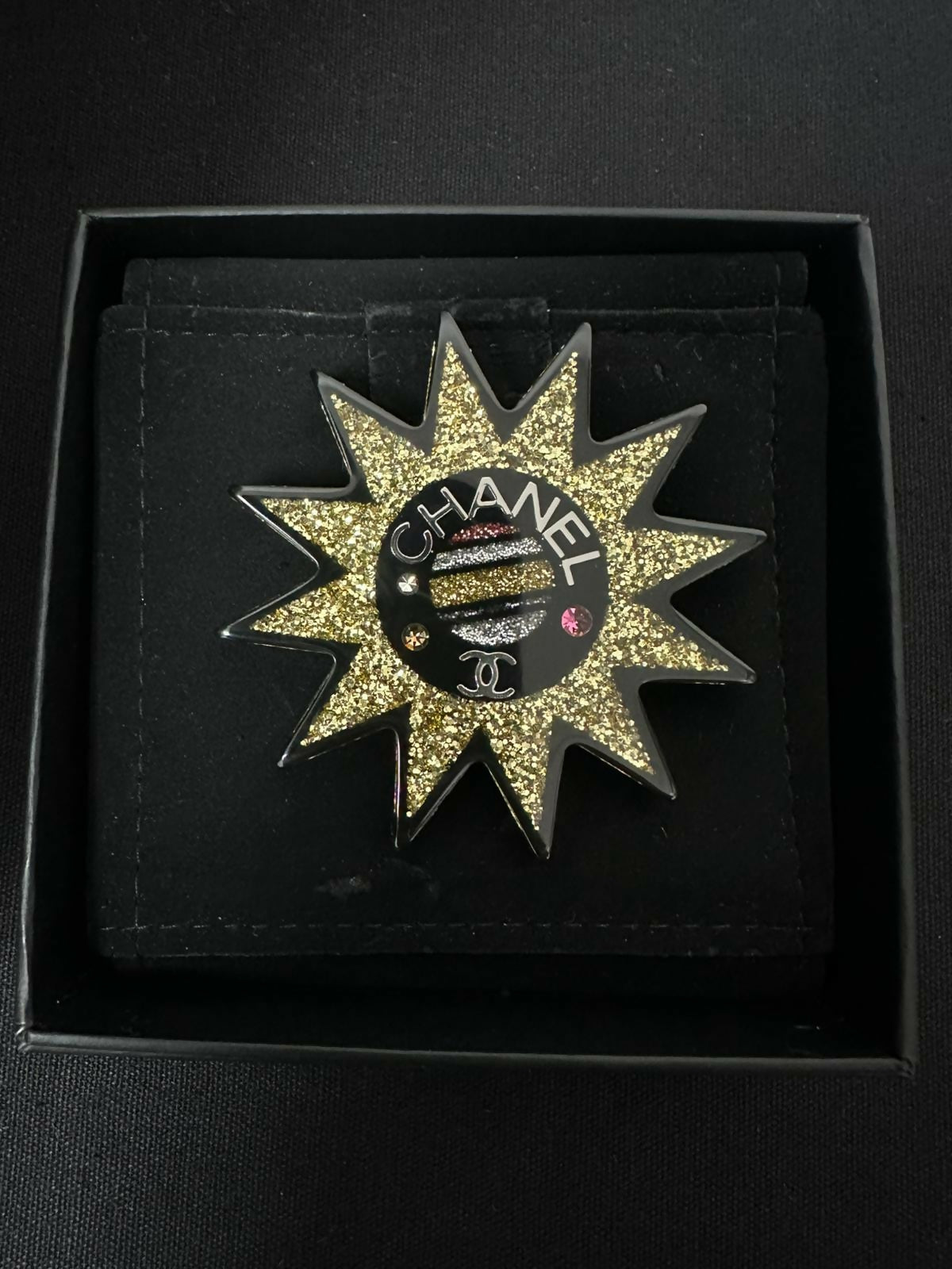 Chanel 17K Acrylic Black
Gold Micro-Sparkle Sun Brooch