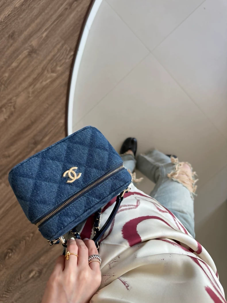 Chanel 22 makeup bag with a dark denim handle and chain