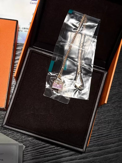 Hermès Kelly bag diamond and pink sapphire pendant necklace