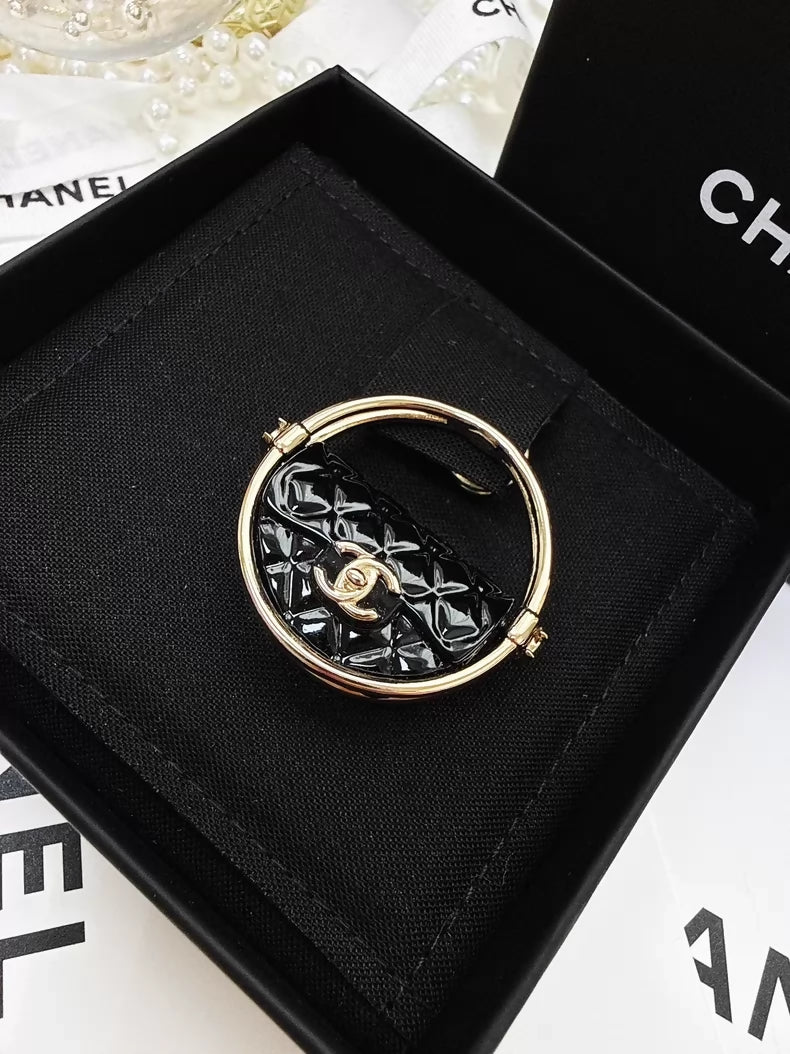 Chanel 23c gold and black acrylic bag with hula hoop-shaped round brooch