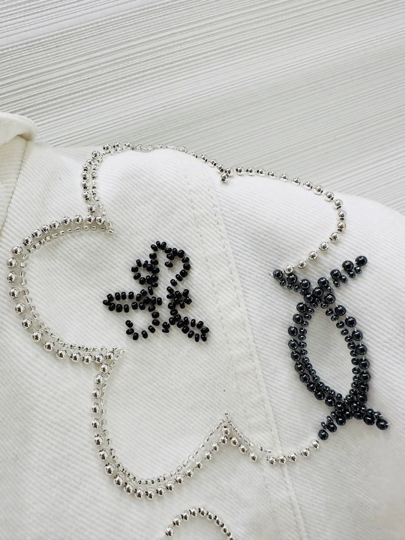Chanel Métiers d'Art white denim jacket with beaded camellia
