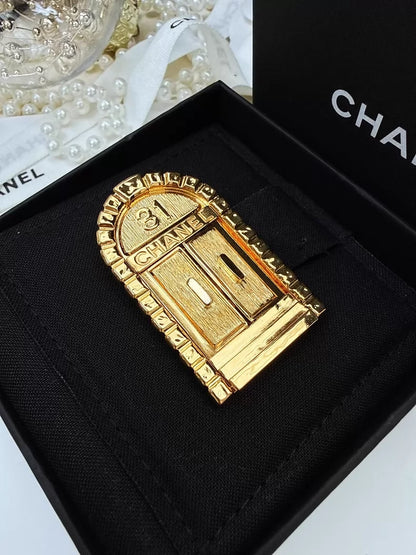 Chanel gold brooch with "31 Rue Cambon"