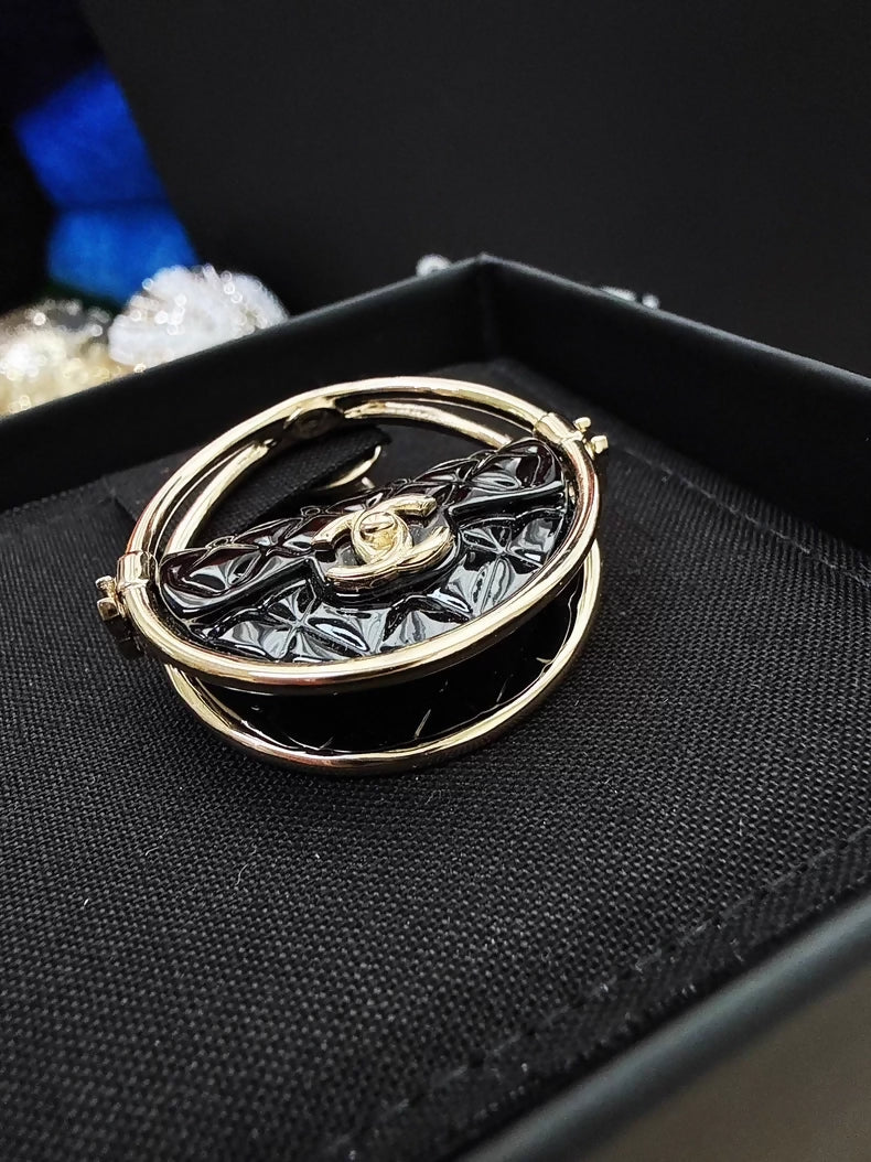 Chanel 23c gold and black acrylic bag with hula hoop-shaped round brooch