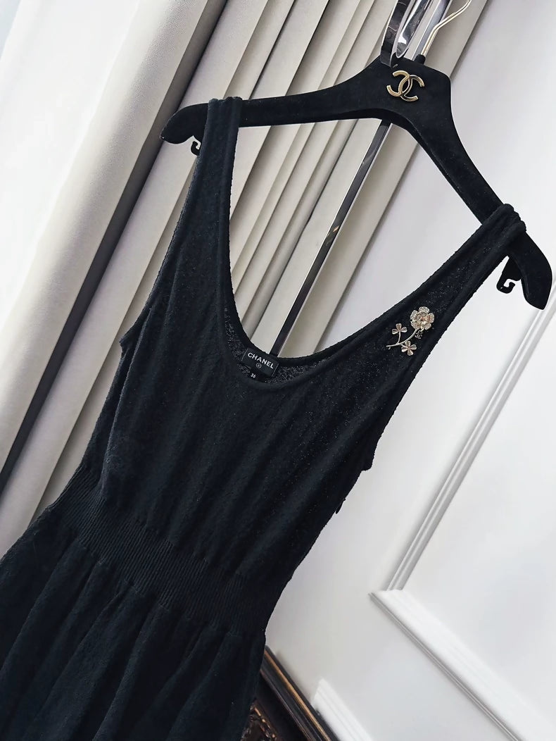 Chanel 25A black dress with camellia brooch