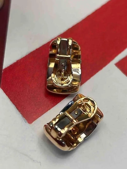 Gold earrings on a red and white background