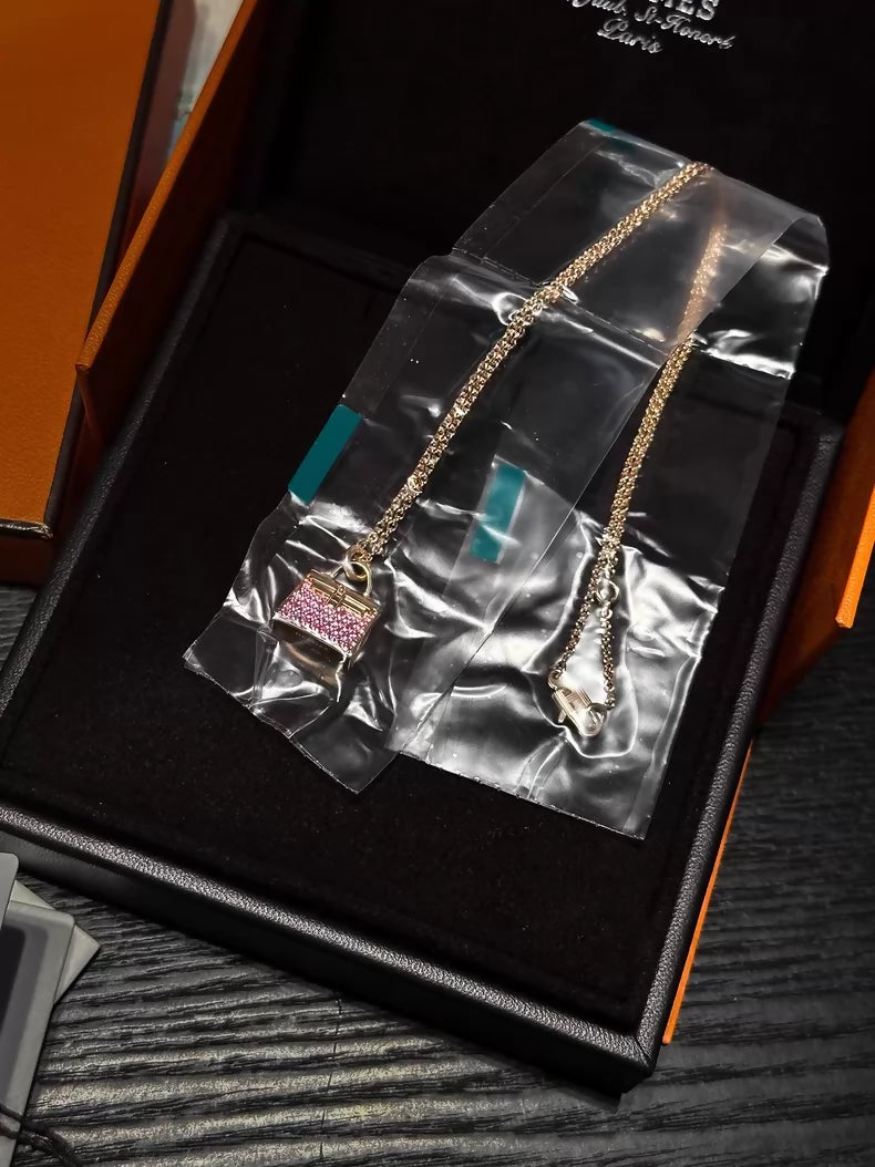Hermès Kelly bag diamond and pink sapphire pendant necklace