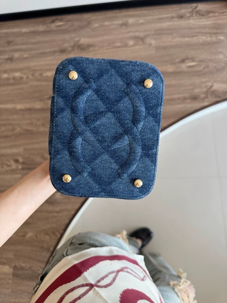 Chanel 22 makeup bag with a dark denim handle and chain