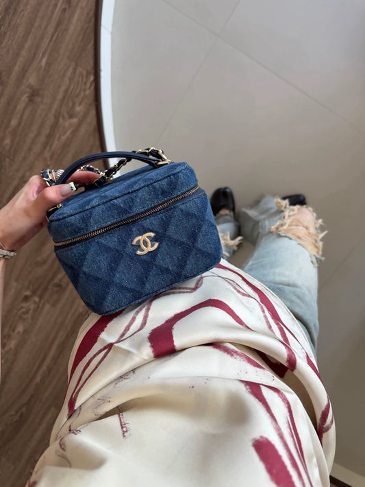 Chanel 22 makeup bag with a dark denim handle and chain