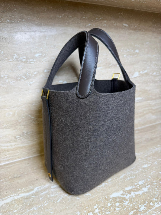 Structured bucket tote in dark grey felted wool with brown leather handles and gold-tone hardware