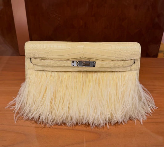 Pale yellow clutch with crocodile-textured flap, feather fringe and silver-tone turn-lock clasp