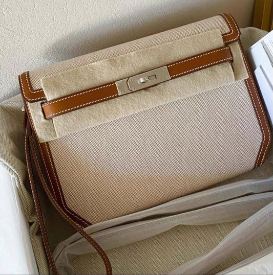 Crossbody bag in beige woven canvas with tan leather trim, white contrast stitching and palladium turn-lock closure