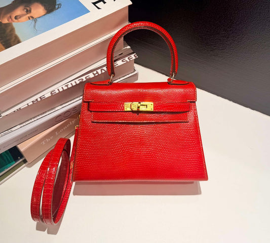 Red lizard-embossed top-handle bag with gold turn-lock closure, single rolled handle and detachable shoulder strap
