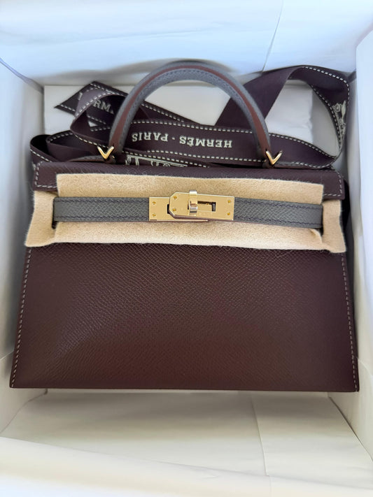 Hermès Kelly handbag in deep burgundy-brown grained leather with grey strap and handle and gold-tone turn-lock hardware