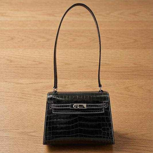 Black crocodile-embossed leather shoulder bag with silver-tone turn-lock and contrast white stitching, single long strap