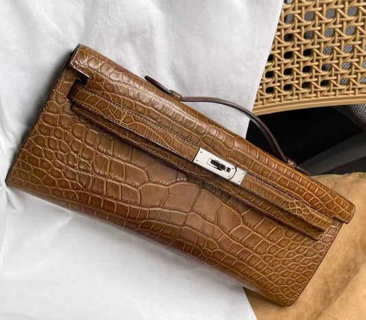 Hermès Kelly Cut clutch in tan crocodile leather with palladium turn-lock closure and slim top handle