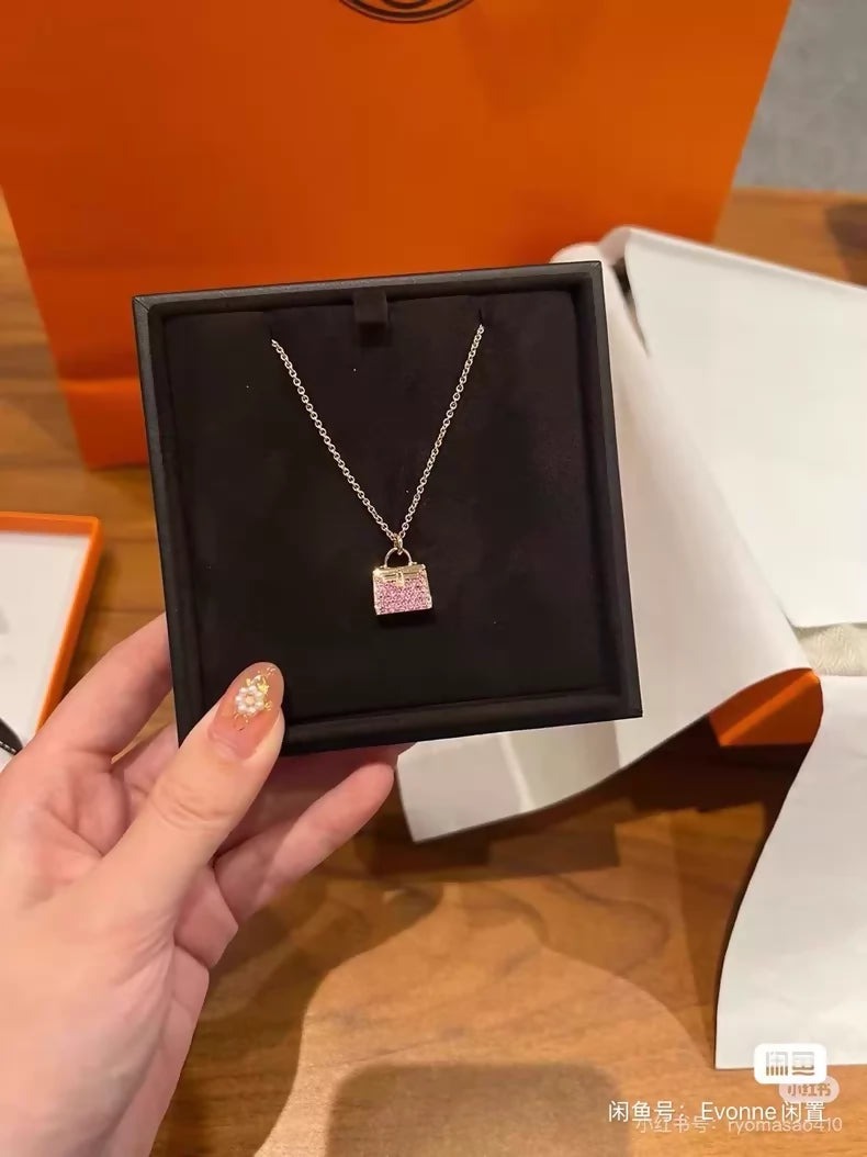 Hermès Kelly bag diamond and pink sapphire pendant necklace