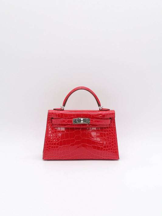 Red crocodile-embossed Kelly mini handbag with palladium turn-lock and single top handle